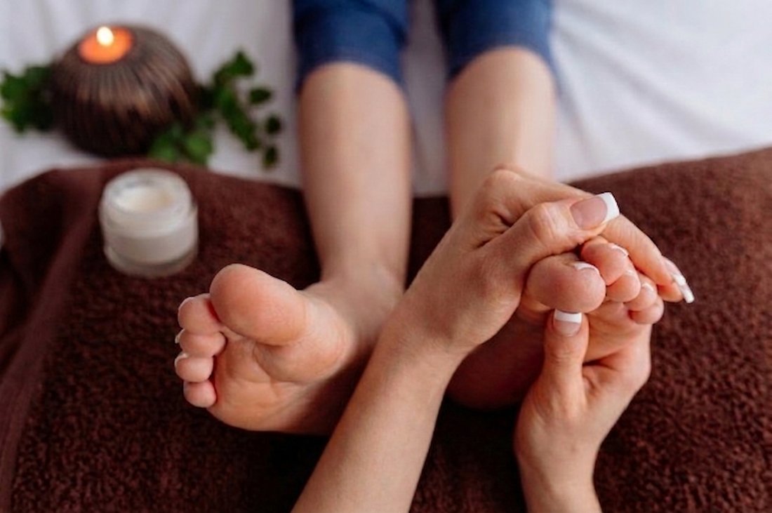 Sessão de reflexologia podal, com vela e ambiente calmo
